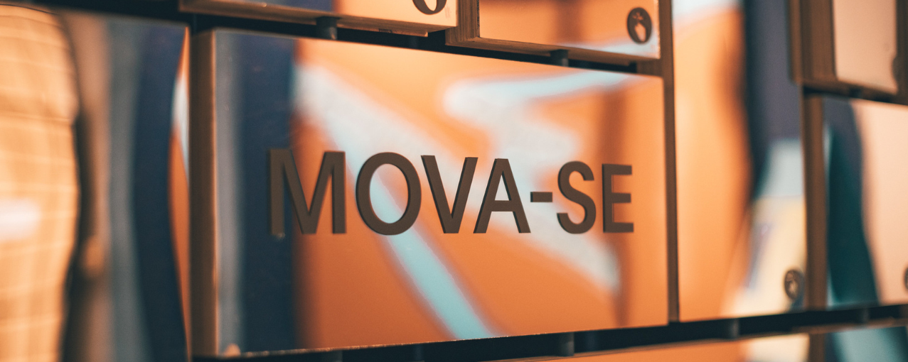 A imagem apresenta um elemento retangular espelhado com a inscrição "Mova-se", presente na mostra temporária "Mova-se: Clima e Deslocamentos".